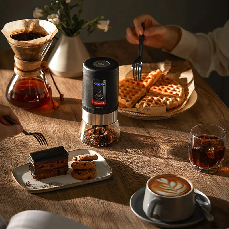 Black portable hand crank coffee grinder with manual grinding mechanism on counter