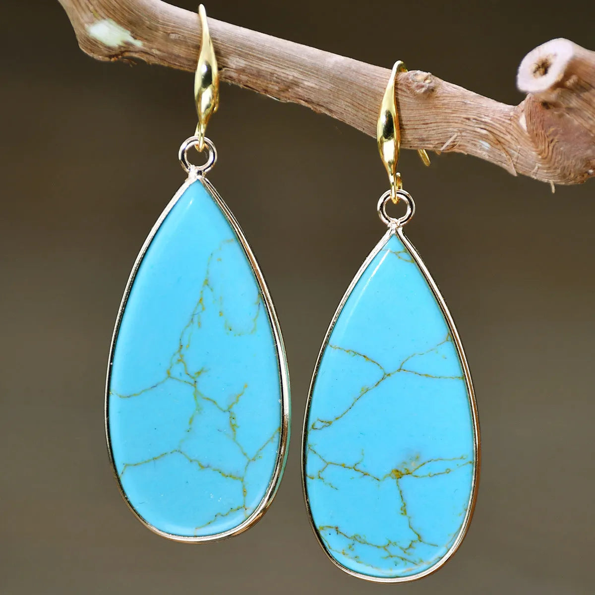 Vintage long water drop earrings in tigereye stone with textured surface and dangle silhouette