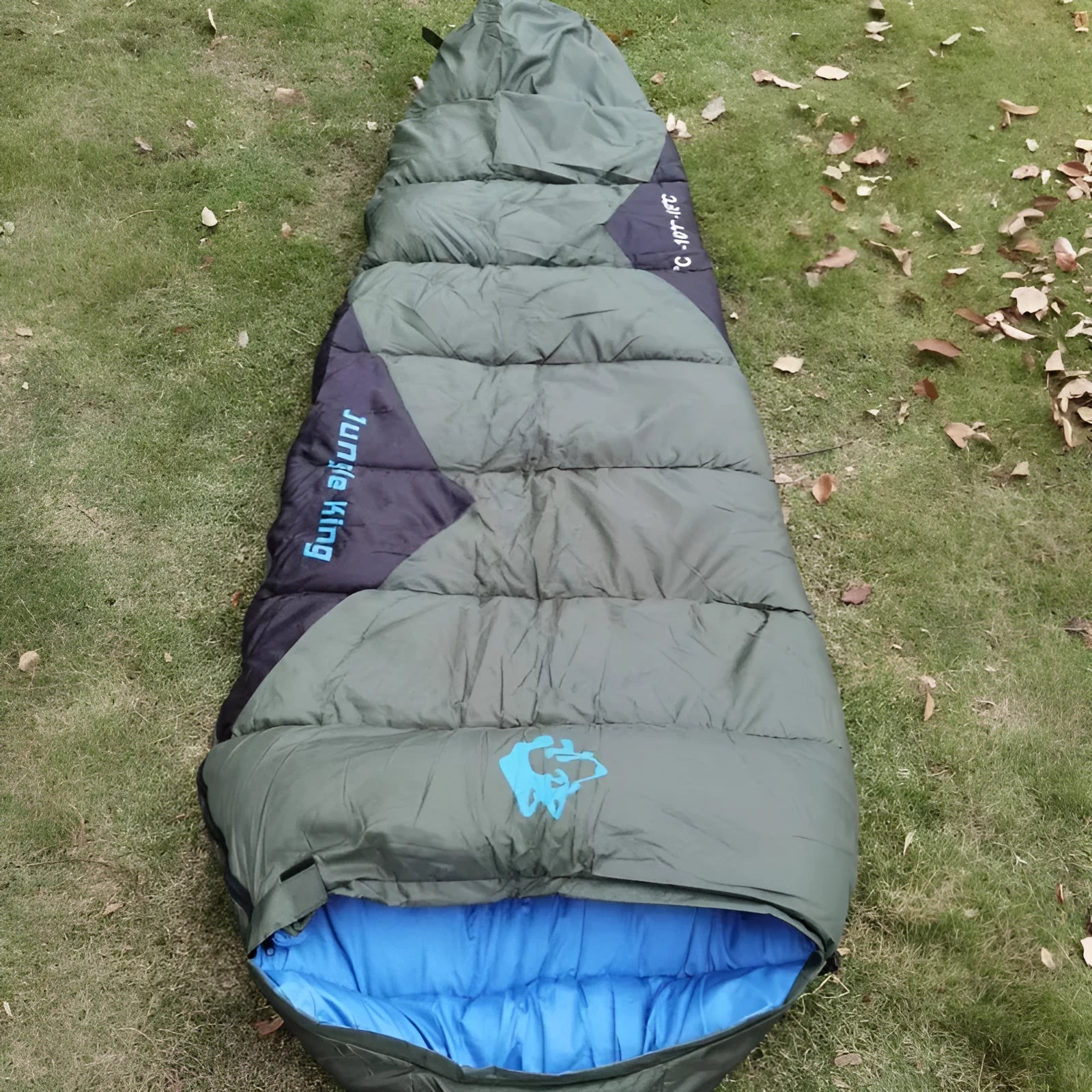 Army green cotton-filled camping sleeping bag with compression storage sack.