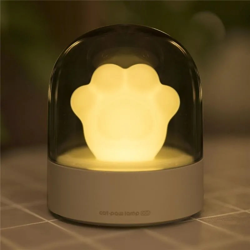 Grey or pink cat paw shaped USB rechargeable night light with rotating soft light and music box feature