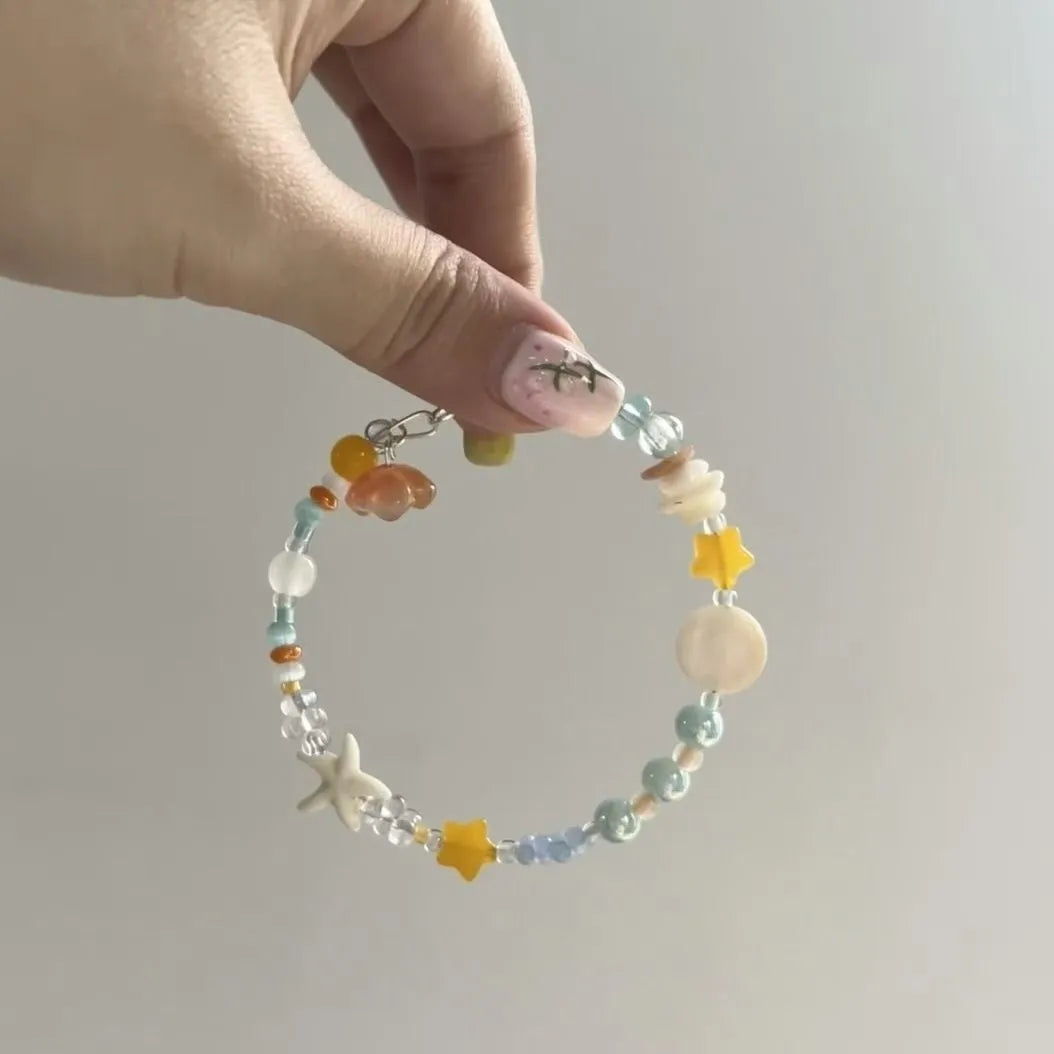 Diamond-shaped mixed-material bracelet for women in orange and sea summer colours with round design elements.