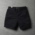 Men's loose fit cotton shorts in a straight-leg style with a zipper fly, shown in a camouflage print colour.