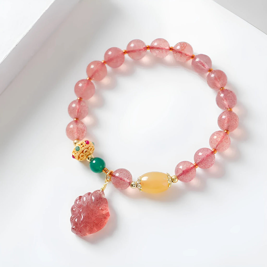 Women's Nine Tail Fox style strawberry quartz crystal beaded bracelet on wrist.