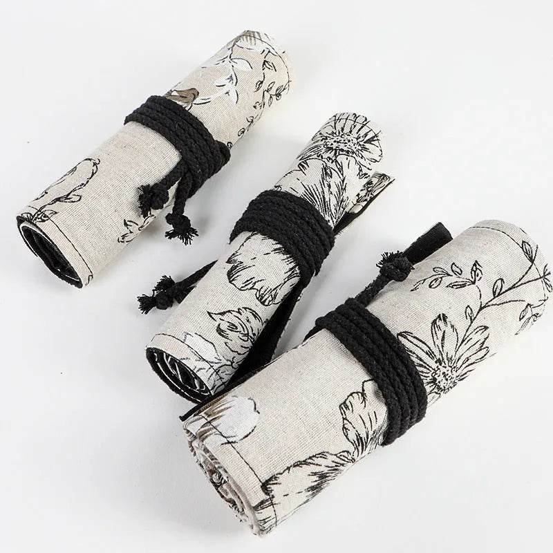 Black peony floral print canvas pencil roll bag open to show multiple tool holes.