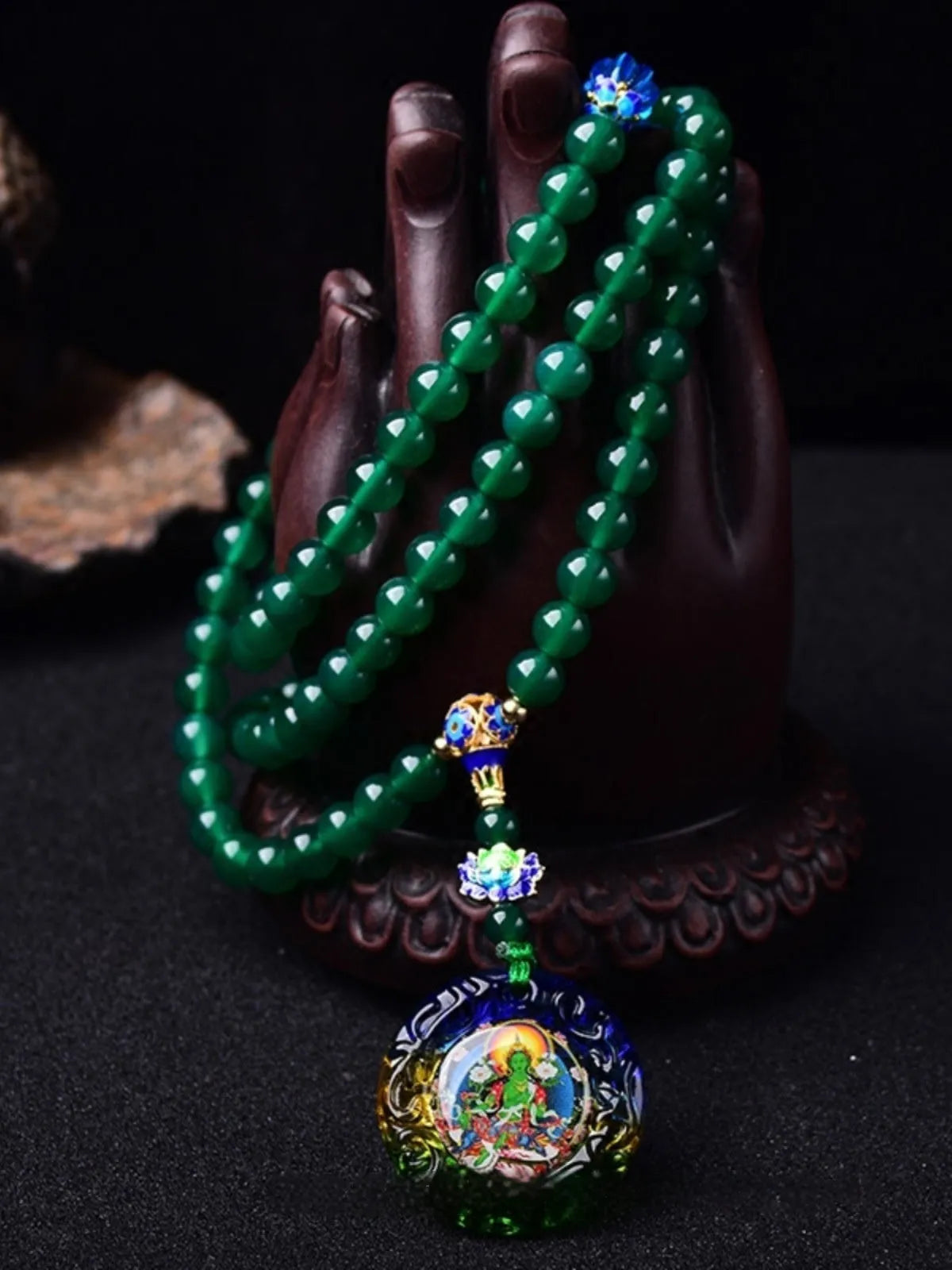 Handmade natural green agate 108 bead bracelet with thangka pendant on a wrist.