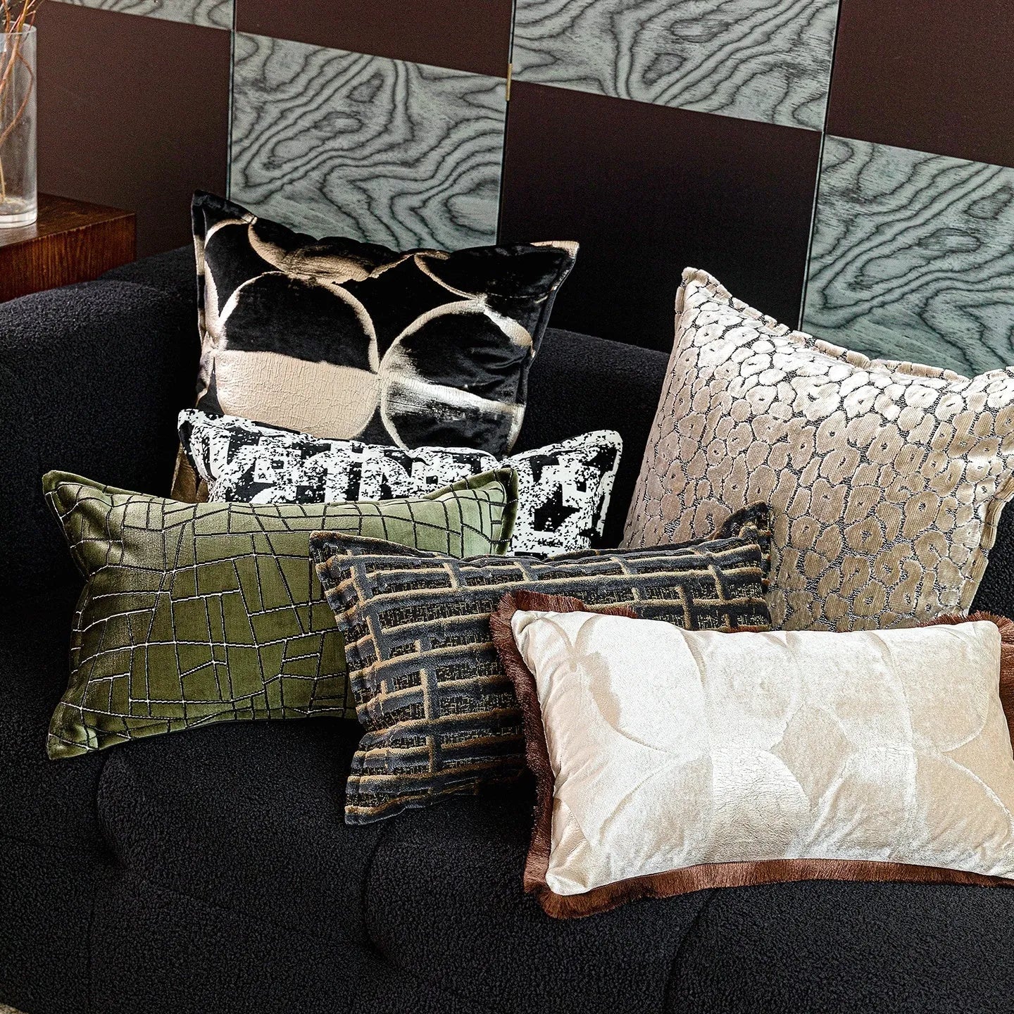 Black gold abstract pattern decorative cushion with removable cover in 45x45cm square size on a grey sofa.