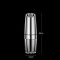 Black and white electric salt and pepper grinder set with USB charging cable on a kitchen worktop.