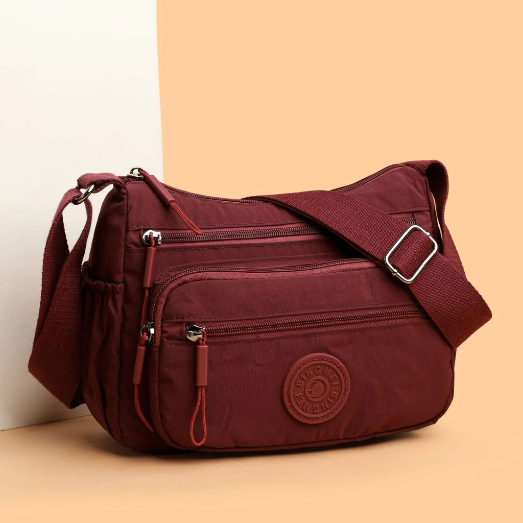 Water-repellent nylon crossbody bag with three-dimensional pocket in black, grey or red