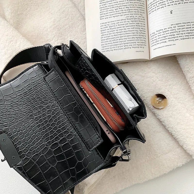 Vintage PU leather crossbody bag in black showing interior organisation for phones and wallets