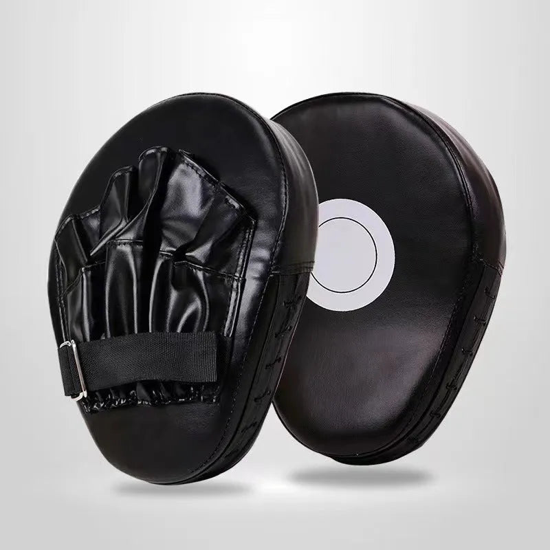 Red and black curved boxing punch mitts held in a trainer's hands for Muay Thai or Sanda practice.