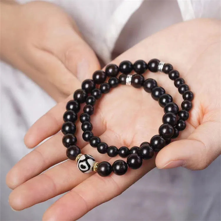 Dark ebony wood bracelet with 8mm Tibet-style beads and circle elements on wrist