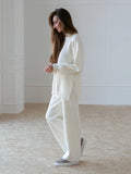 Women's turtleneck knit sweater suit set in solid colour with long sleeves and matching trousers on display