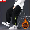 Men's grey green loose-fit cargo trousers with visible stitching detail and a banded ankle opening.