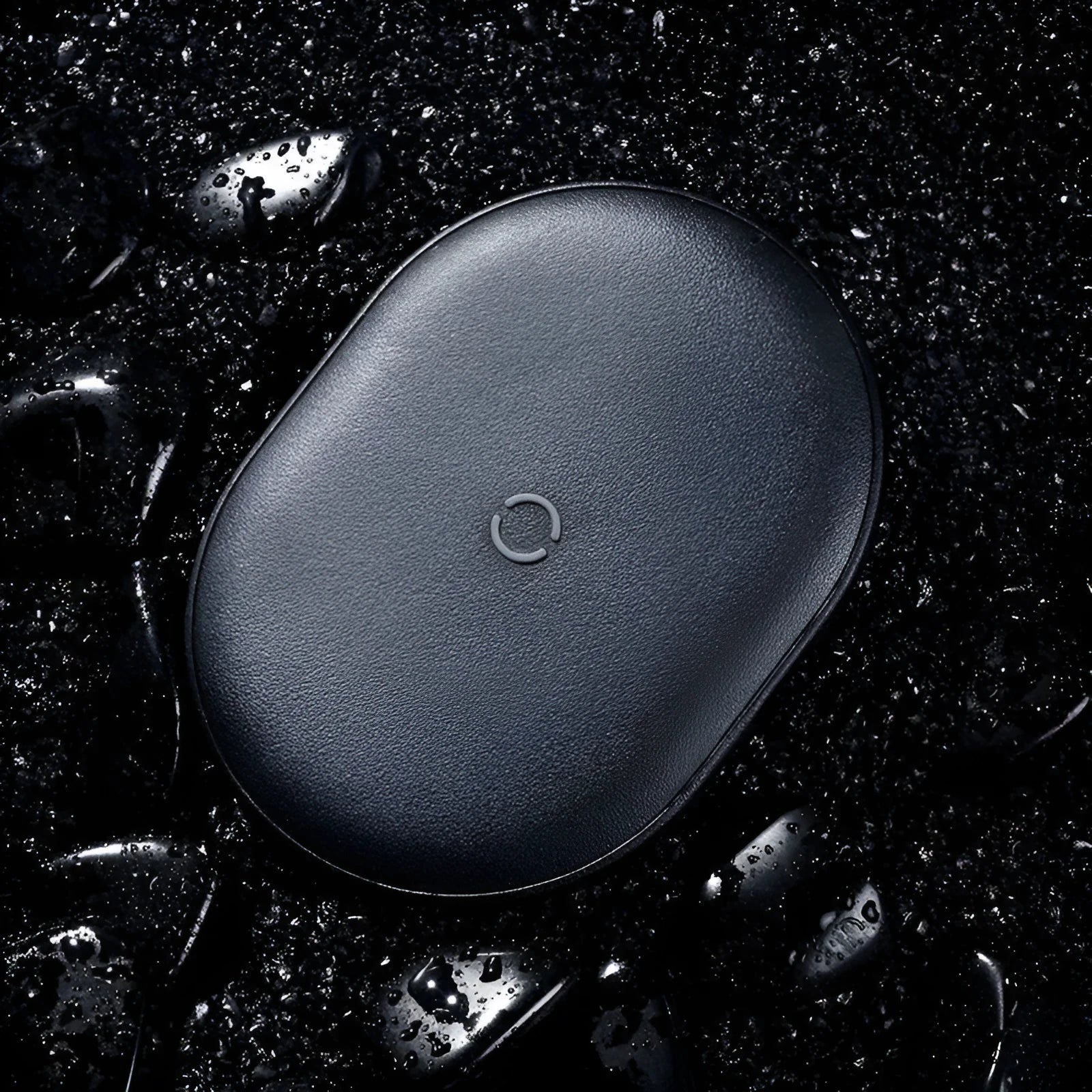 Baseus Rough 15W wireless charging pad in black on a desk next to a mobile phone.