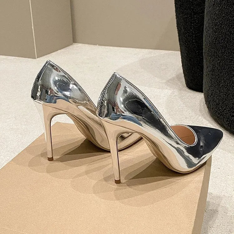 Gold metallic women's pointed toe slip-on pump with a tall stiletto heel on a white background.