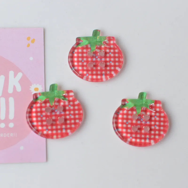 A pack of medium-sized plastic tomato button ornaments in mixed colours including red plaid and cherry tomato print.