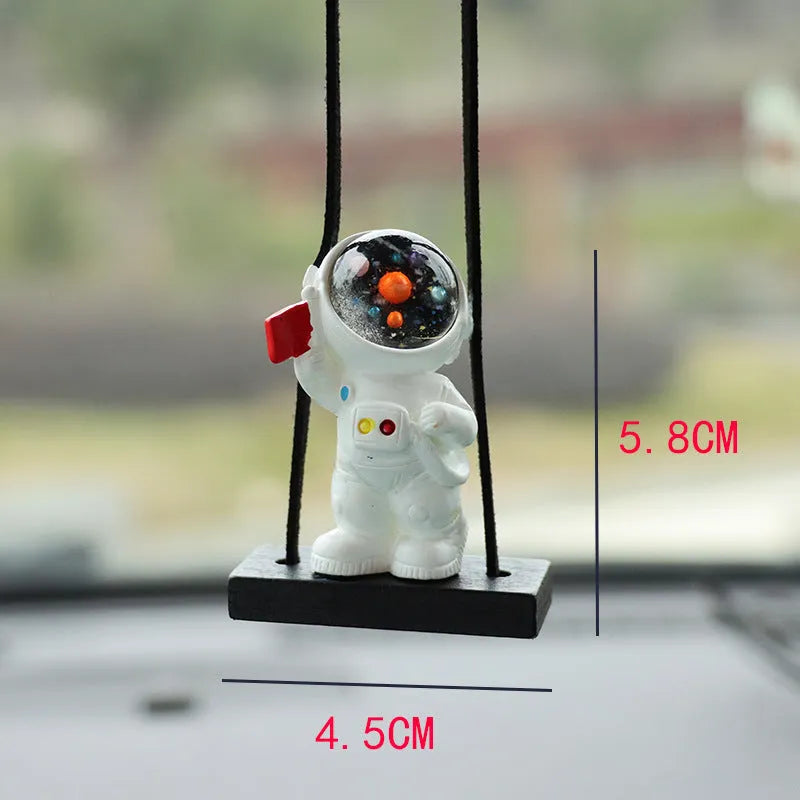 Resin astronaut car pendant showing cartoon astronaut designs including telescope, red flag, and radish variations