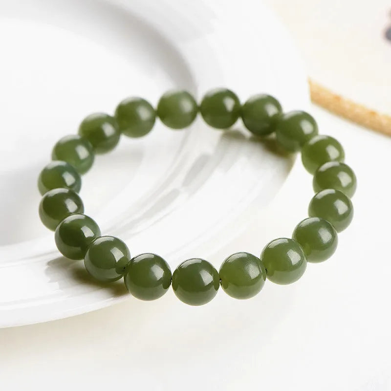Polished Hetian jade ball bracelet showing different bead sizes on a wrist, in clear ice-like colours.