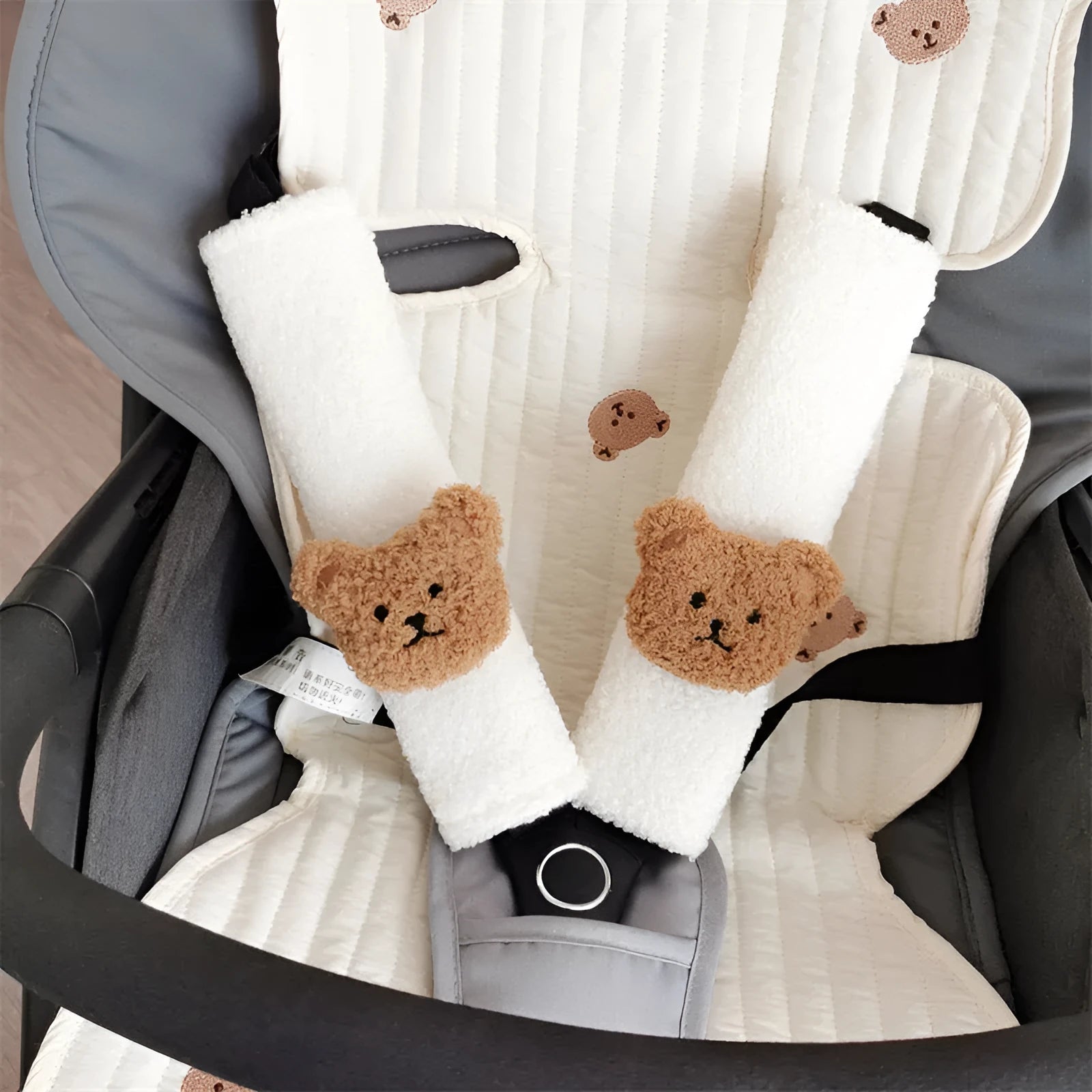 Close-up of a khaki-coloured plush bear seat belt cover on a car seat strap.