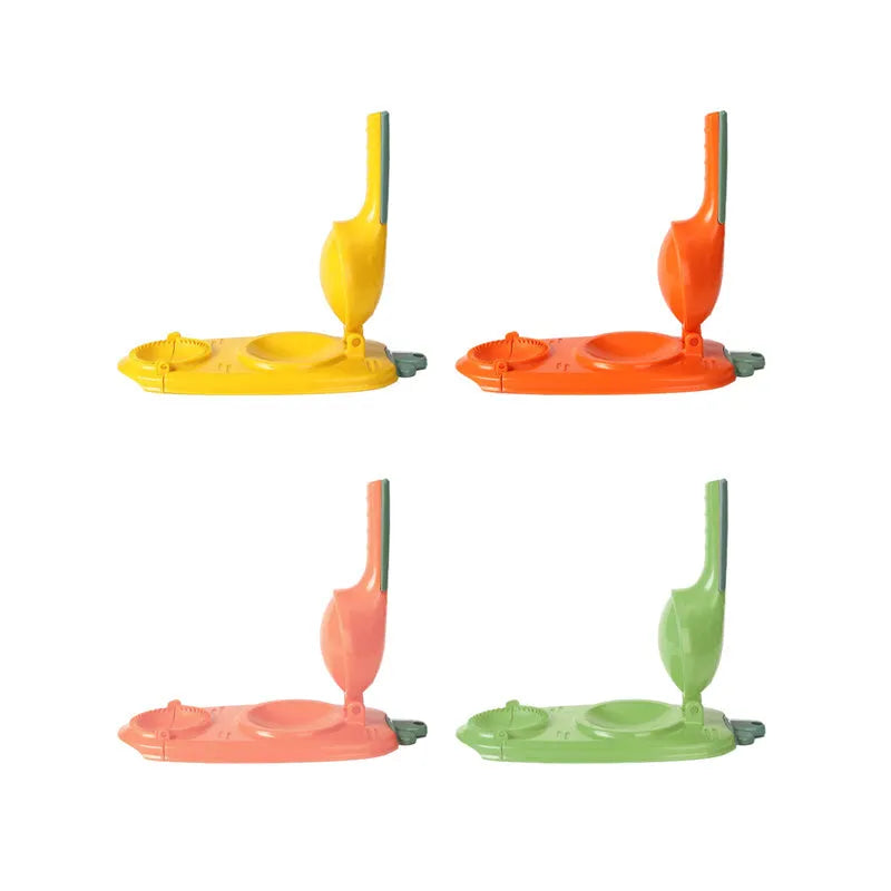 Orange and white manual kitchen dumpling press tool with ergonomic handle on wooden table