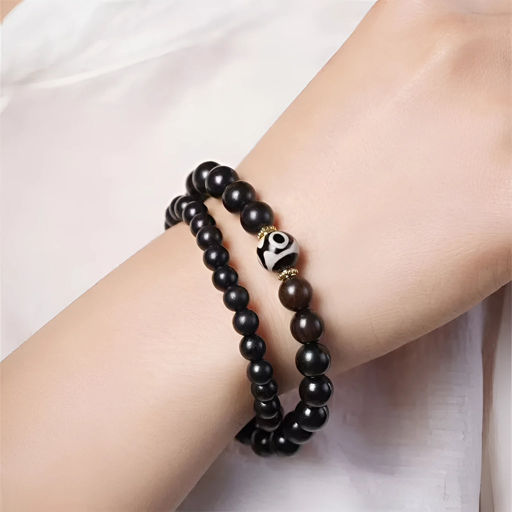 Dark ebony wood bracelet with 8mm Tibet-style beads and circle elements on wrist
