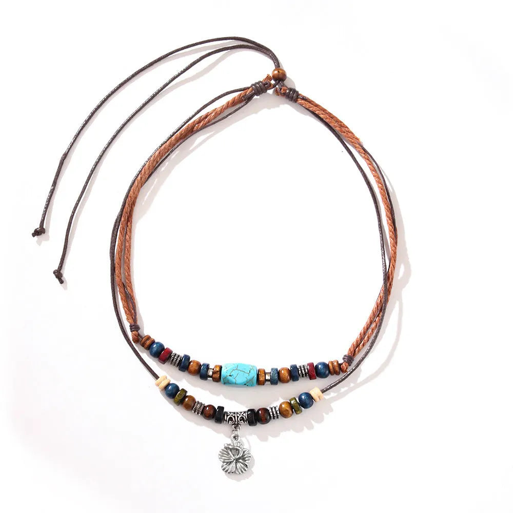 Men's retro necklace with geometric flower pendant and turquoise wooden beads on a wax rope chain.