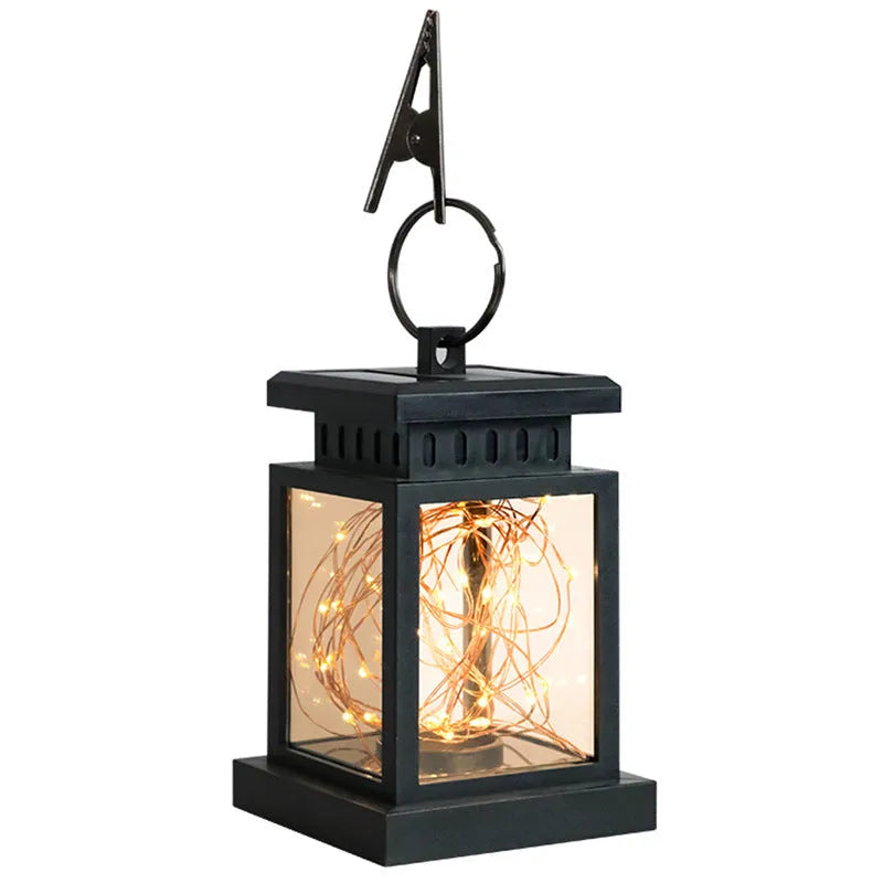 Black solar wind lamp with warm white LED light on outdoor table