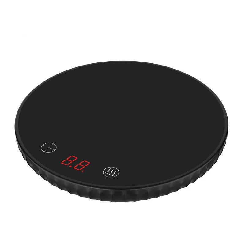 Electric waterproof cup warmer with digital display and touch switch on desk next to a mug of tea