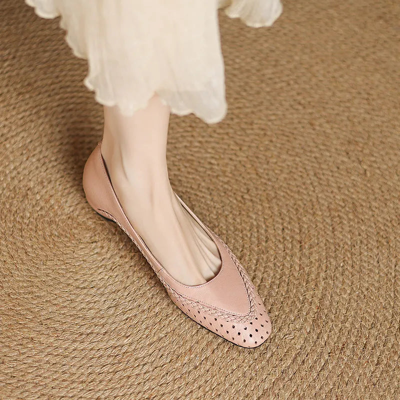 Women's beige mid-heel sandals with hollow-out design and round toe on a light background.