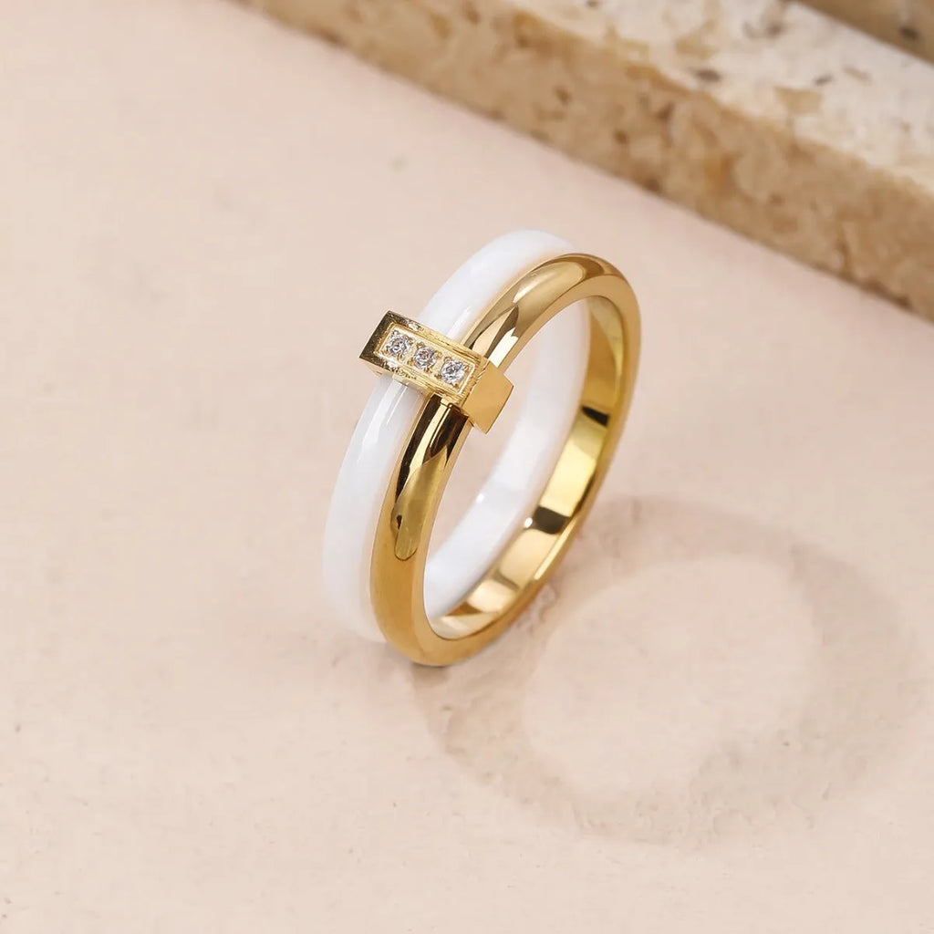 Women's heart-shaped titanium steel ring with glossy stitching and zirconium detail in gold black, golden white, and steel white.