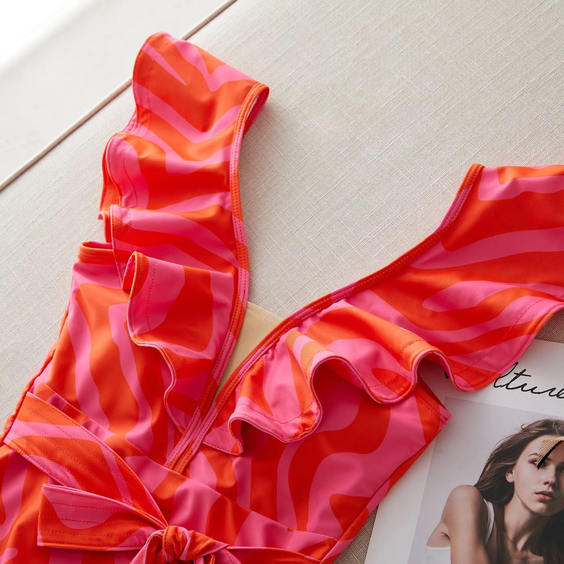 Women's one-piece swimsuit with ruffled straps, deep V-neck, and mesh stitching in a printing colour pattern.