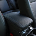 Embossed fibre leather car armrest box cushion measuring 32cm by 19cm in black with red trim