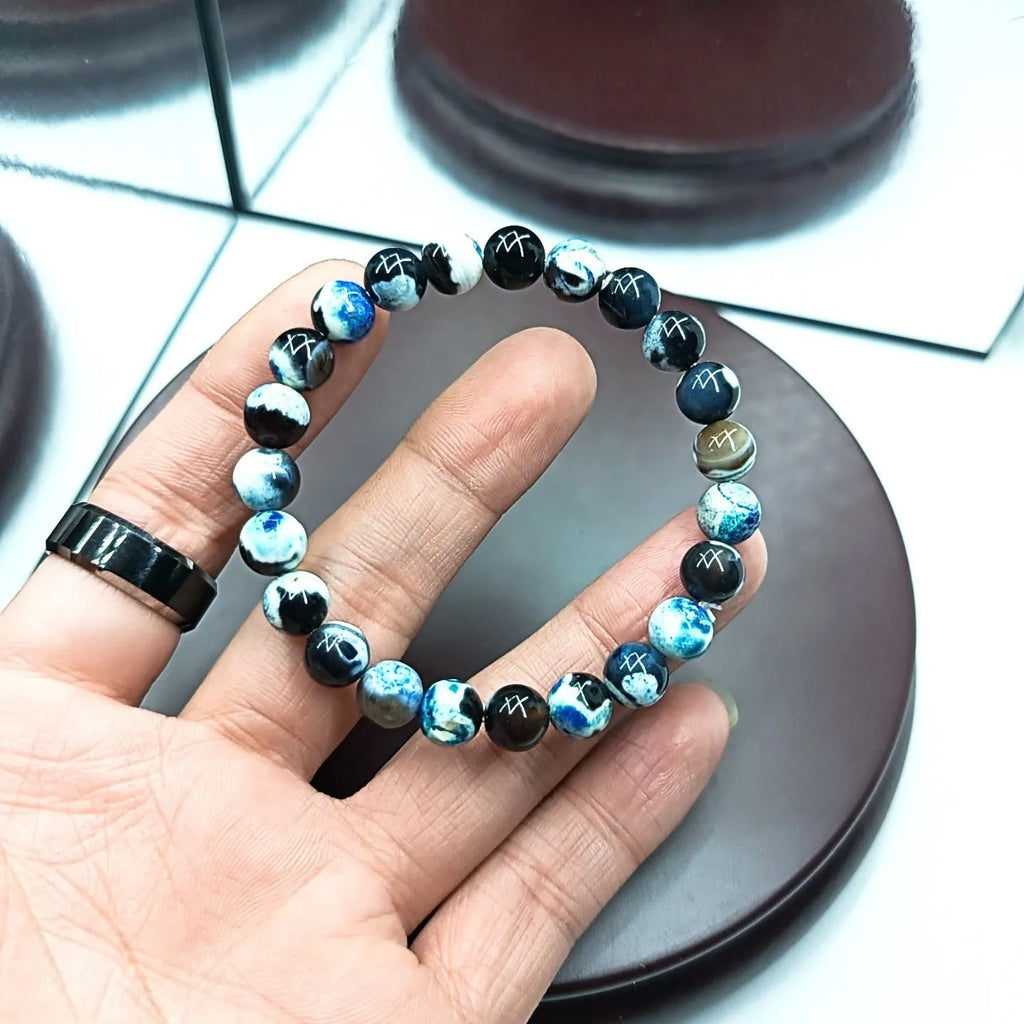 Close-up of a handmade Bohemian bracelet with round 8mm agate-style glass beads on a wrist.