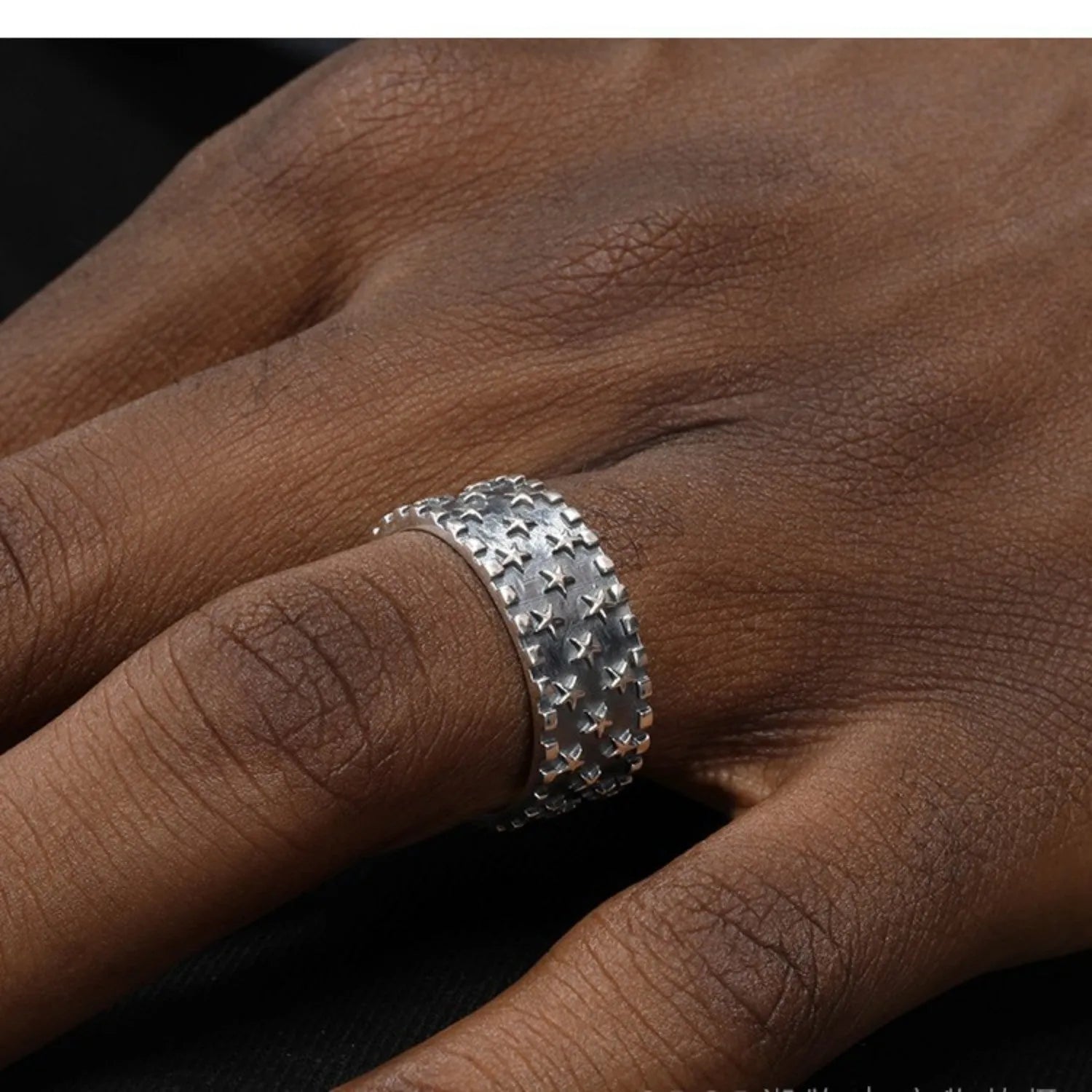 Adjustable open-ended sterling silver ring with a geometric multi five-pointed star pattern.