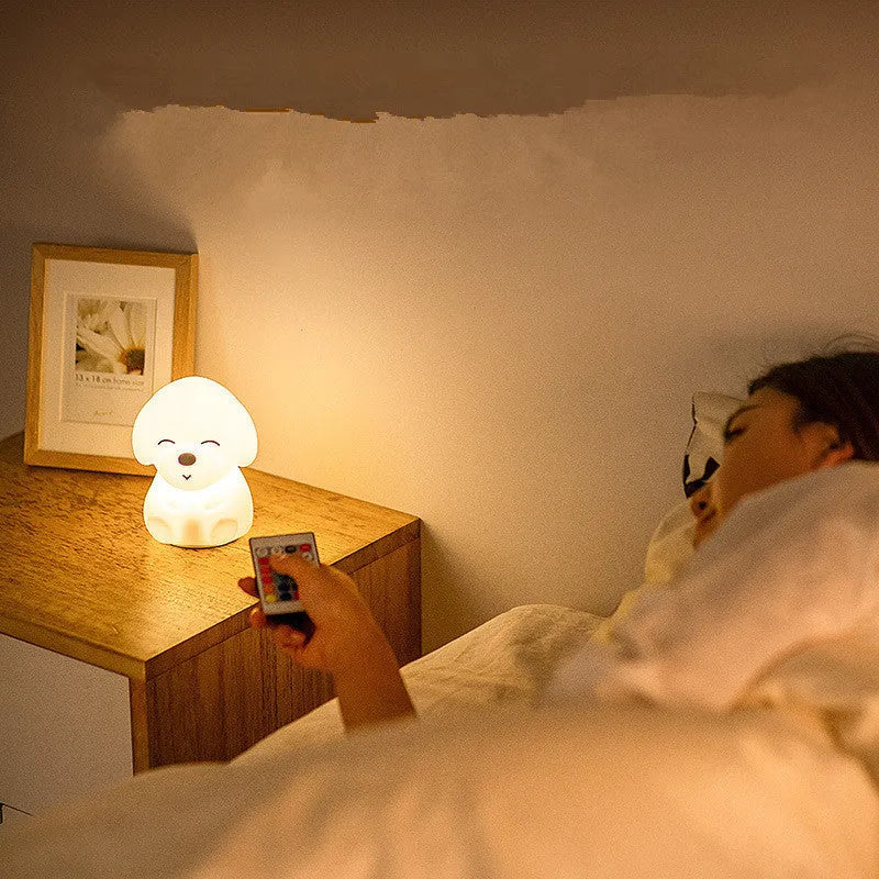 White silicone puppy-shaped LED night light with soft glow on a flat surface