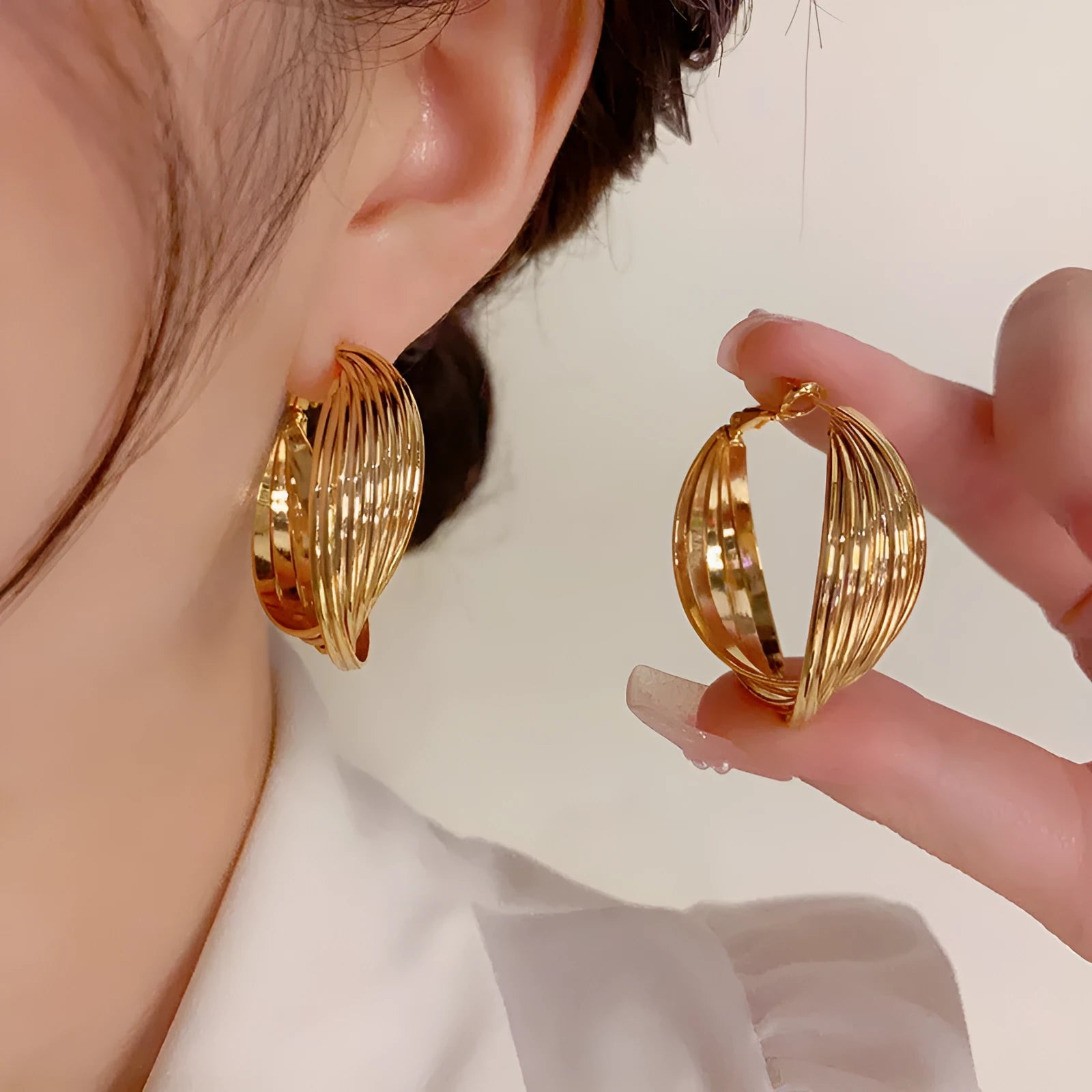 Twisted metal eardrop earring with real gold plating, geometric round shape, and stranded multi-layer design in gold colour