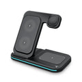 Wireless foldable fast charger in black charging a phone, headset, and watch on a desk