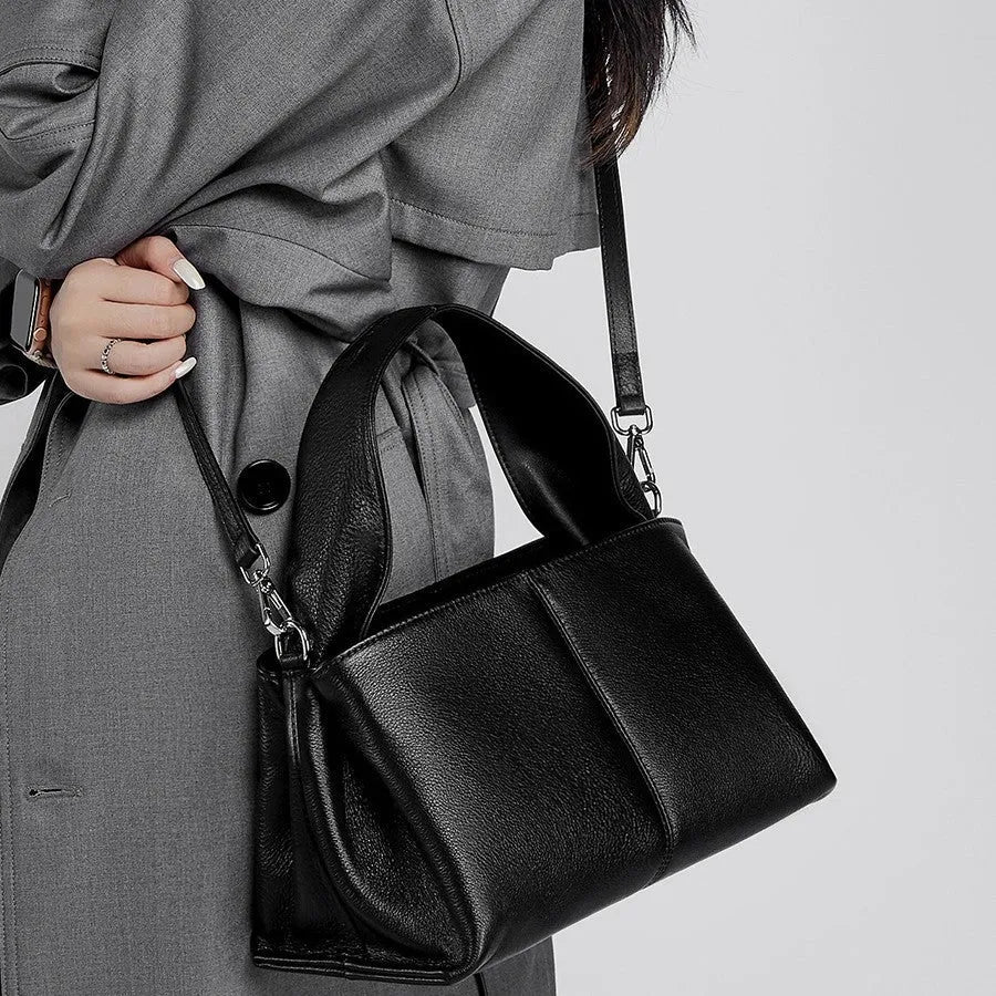Women's brown retro texture leather messenger bag with a double shoulder strap shown on a table.