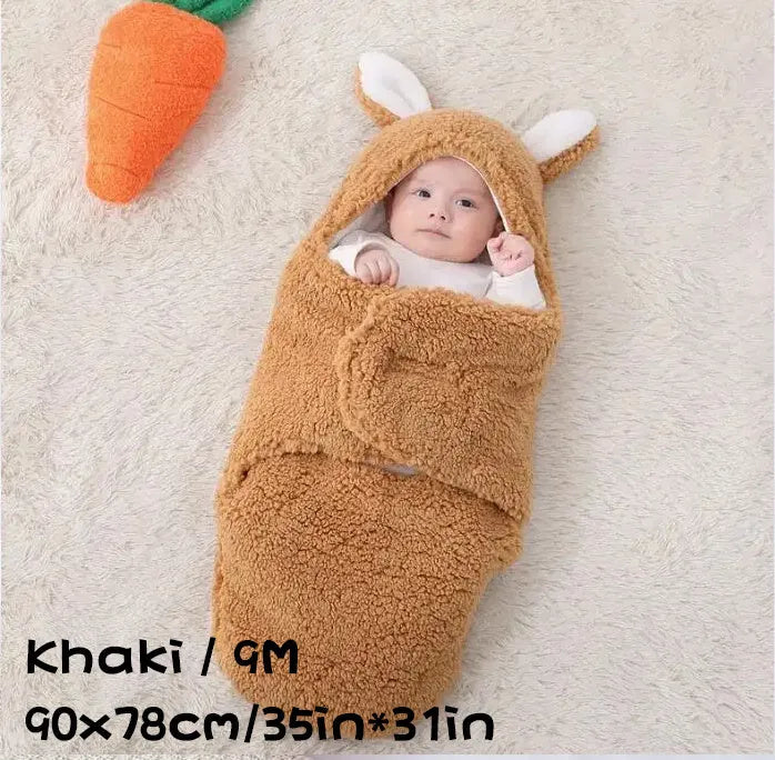 A baby wearing a soft grey fleece sleeping bag with hook-and-loop shoulder straps.