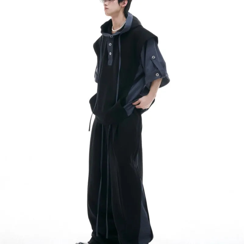 Man wearing a grey hooded short-sleeve sweatshirt and matching trousers with three-dimensional stitching detail.