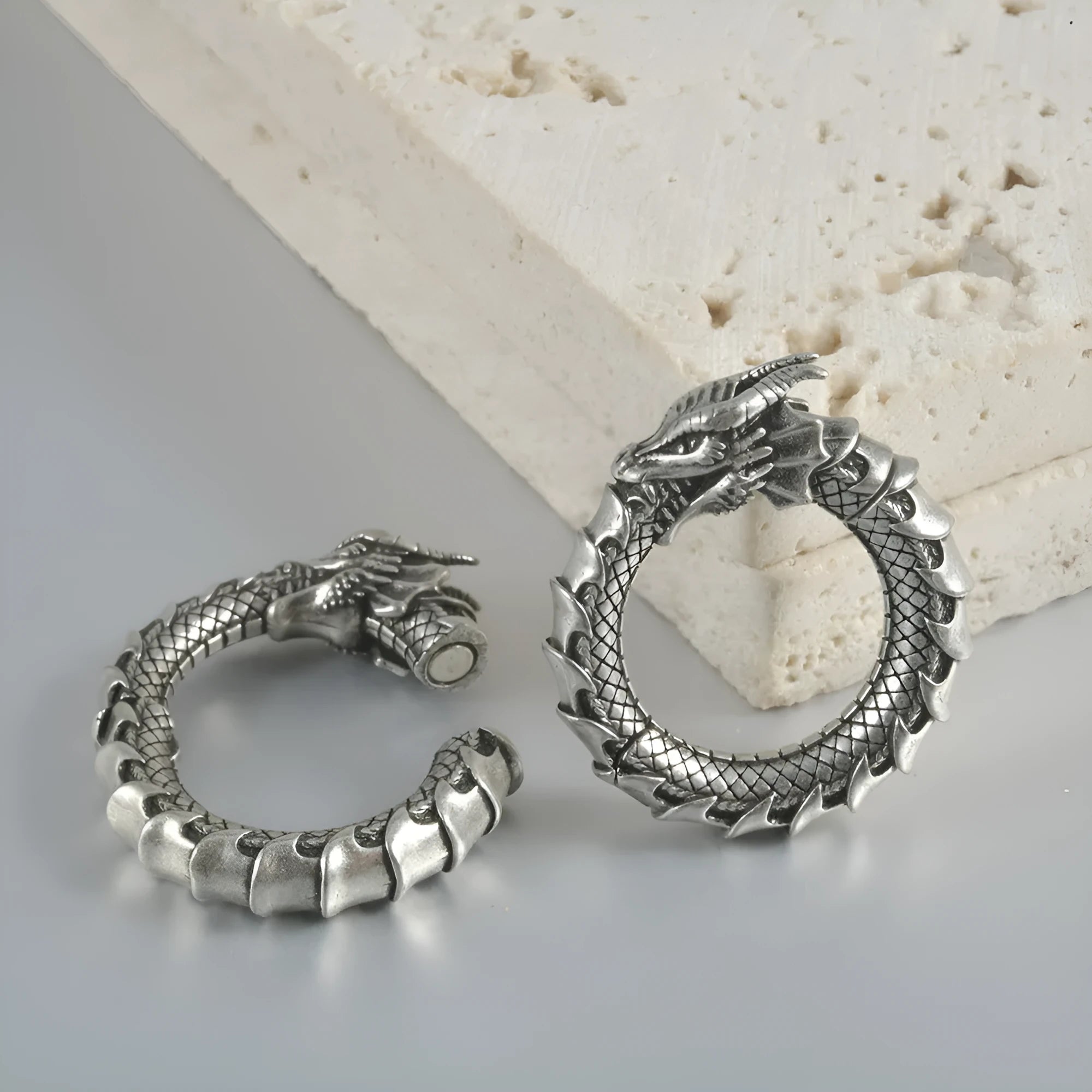 Large antique silver dragon-shaped earrings with hollow-out geometric design.