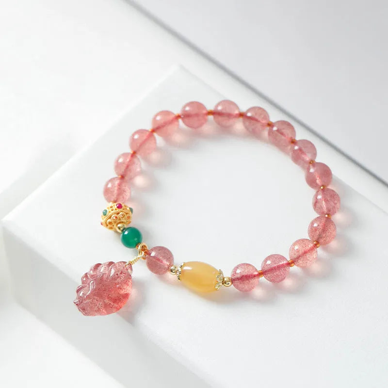 Women's Nine Tail Fox style strawberry quartz crystal beaded bracelet on wrist.