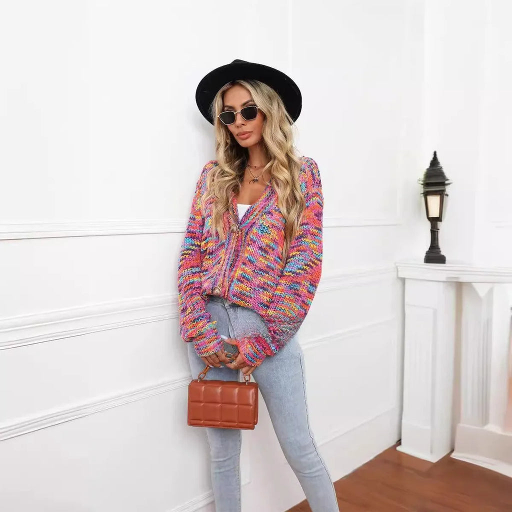 Rose red loose fit knitted cardigan coat with rainbow coloured stripes, shown on a model.