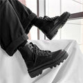 Black frosted leather Dr Martens boots with white laces and a side zipper on a high-top 8-hole design.