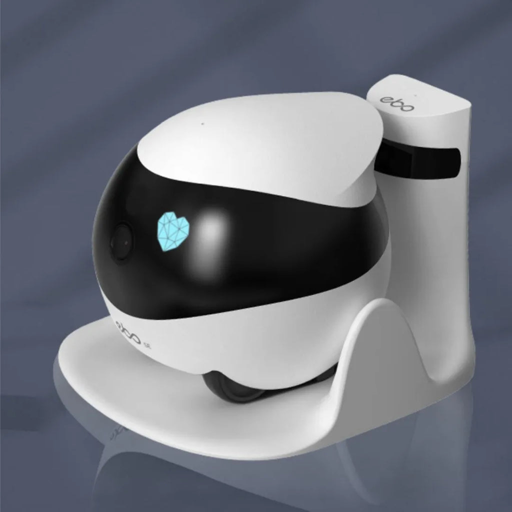 White smart home mobile surveillance robot camera with front sensors on a docking station.