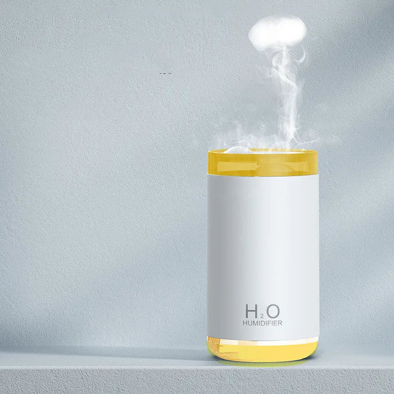 White USB jellyfish smoke ring humidifier with warm night light on a table, showing nano mist.