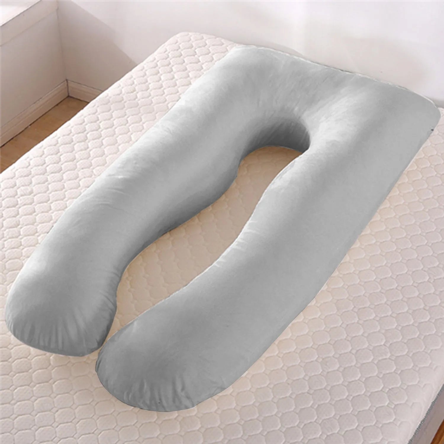U-shaped white maternity pillow with ice silk cover on a bed, showing its full-body support shape for pregnancy.
