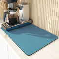 Square super absorbent drain mat with rubber backing in black or blue on a kitchen counter.