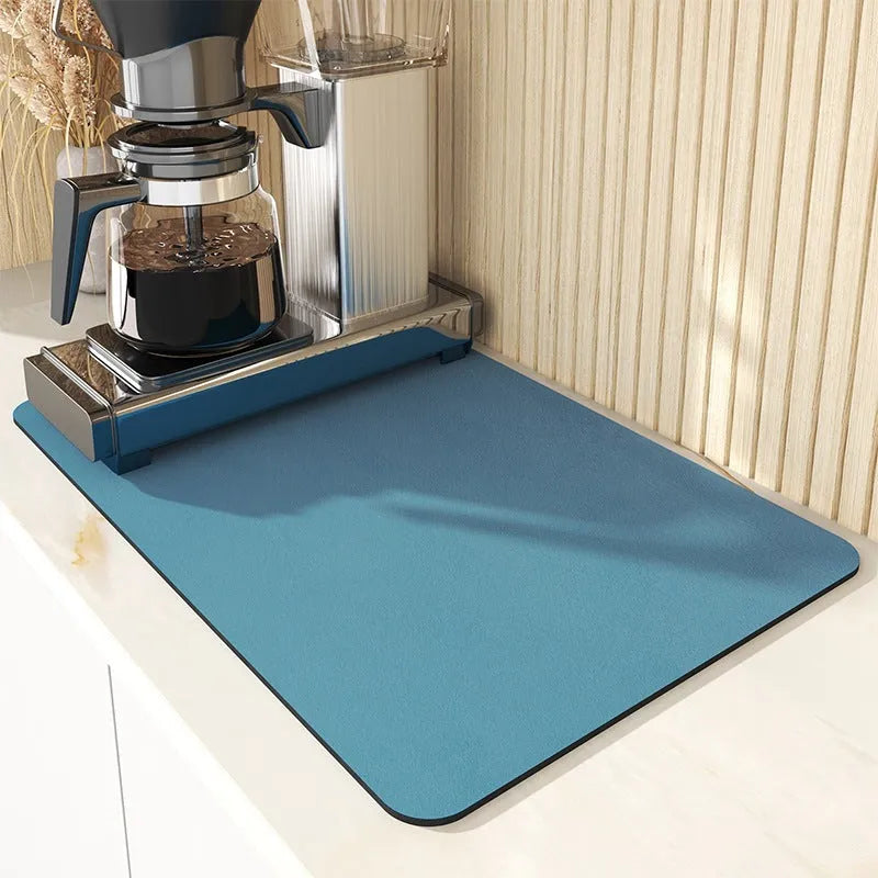 Square super absorbent drain mat with rubber backing in black or blue on a kitchen counter.