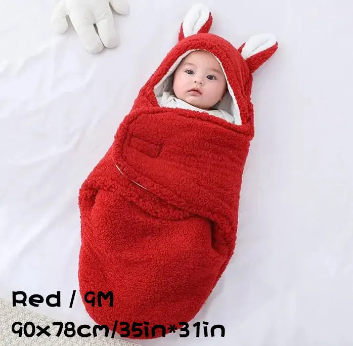 A baby wearing a soft grey fleece sleeping bag with hook-and-loop shoulder straps.